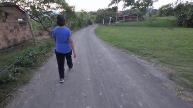 Yaşlı emekli kadın ormanda çakıl yolda yürüyor.