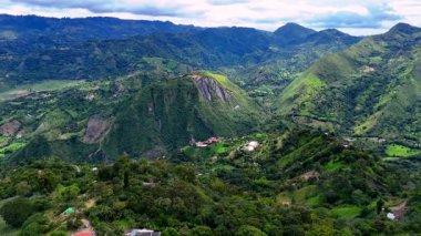 Bir ormanın üzerinde uçan hava manzarası ve bir drondan dağlardaki evler