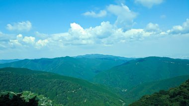 Sis ve mavi bulutlarla dolu güzel dağlar.
