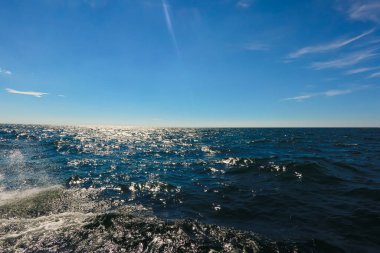 Manzara berrak bir gökyüzünün altında pırıl pırıl mavi bir okyanus..