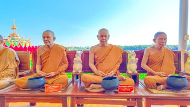 Chachoengsao, Tayland, 11 Kasım 2024; Parlak mavi gökyüzü arka planına sahip sandalyelerde oturan keşişler