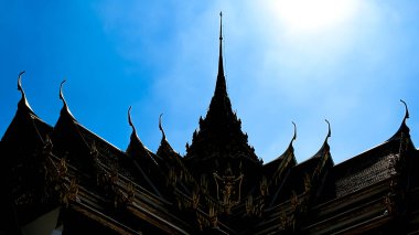 Bangkok, Tayland - 11 Kasım 2024: Parlak mavi gökyüzüne karşı bir tapınak çatısının silüeti.