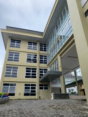 Camdan pencereleri ve girişleri olan büyük bir bina, örneğin kampüs ya da üniversite öğrenci binası