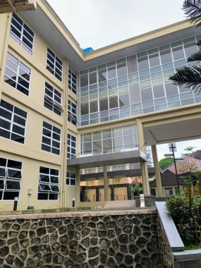 hastane ya da üniversite gibi birçok cam pencere ve girişi olan büyük bir bina.