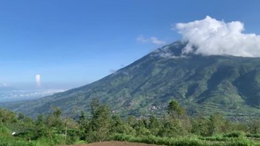 Sabahları dağ manzarası yeşil ağaçlarla çevrili beyaz bulutlarla