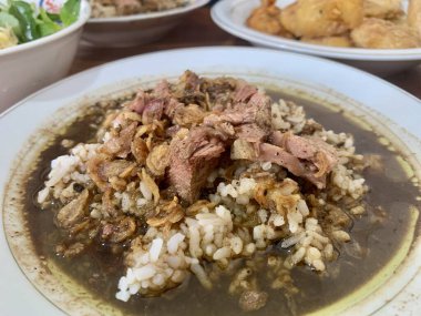 Close-up photo of Rawon (black beef soup). Originating from Ponorogo, East Java, rawon uses black kluwek nuts as its main seasoning, giving the broth its dark color and spicy flavor.