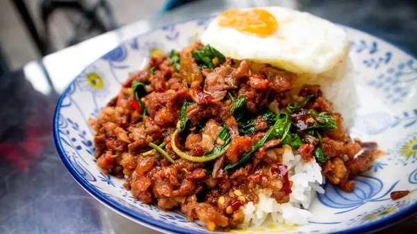 Pad Gaprao (Pad Kra Pao) Kutsal Basil Tavuk Karıştırma Kızartması. Phat kaphrao, Tayland usulü kutsal fesleğen ve sarımsak ile kızartılmış domuz, tavuk, biftek ve deniz ürünleri gibi etten oluşur.