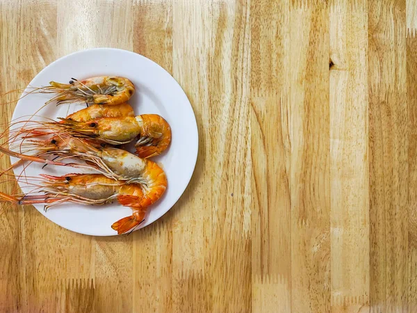 Grilled Fresh Giant River Prawn, white plate on the wooden table, River prawns.Grilled giant river shrimp or prawn, top view