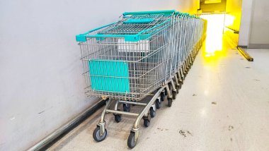 Alışveriş arabası yan görünümü tramvay yeşili, alışveriş arabaları depolama alanında düzgünce istiflenmiş..