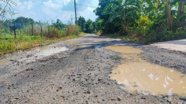 Tamir edilmesi gereken eski asfalt dokusu. Yol çukur ve deliklerle dolu. Çukur yolu - hasarlı kırsal yol yüzeyi 