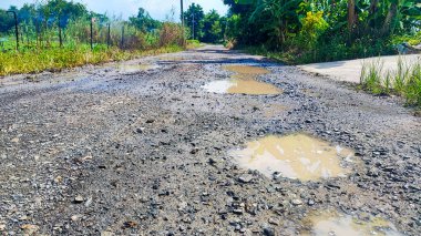 Tamir edilmesi gereken eski asfalt dokusu. Yol çukur ve deliklerle dolu. Çukur yolu - hasarlı kırsal yol yüzeyi 