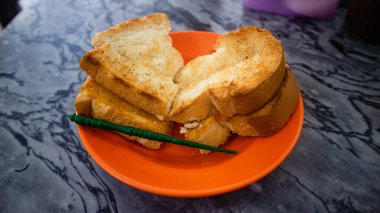 Malezya 'da kahve, nasi lemak, tost ekmeği ve yarım haşlanmış yumurta, kahveli tost seti ve tereyağı ve kaya ile tost ekmeğinden oluşan yaygın bir kahvaltı seti, tipik bir kahvaltı. 