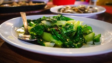 Tabakta istiridye sosu, Çin brokolisi, karışık Çin brokolisi ve istiridye soslu shiitake mantarı ile karıştırılmış.