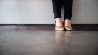 İş kadınının duruşu, bacakları iş yerinde oturup çalışmak. Kadın yüksek topuklu ayakkabı giyer. 