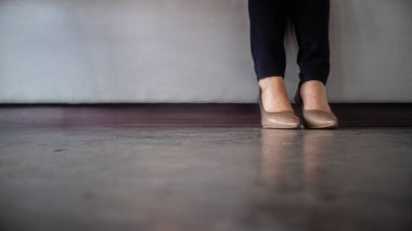 İş kadınının duruşu, bacakları iş yerinde oturup çalışmak. Kadın yüksek topuklu ayakkabı giyer. 