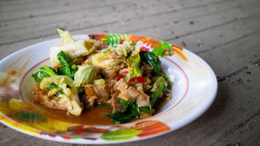  Kızarmış lahana ve beyaz tabakta istiridye soslu çıtır domuz.