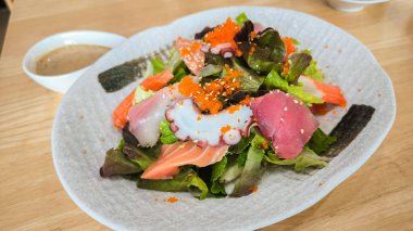 various kind of fresh raw sashimi salad, Japanese spicy salad sashimi salmon with Premium fresh raw salmon. Asian salad with tofu and fresh vegetables Mixed sliced fish sashimi, thin sliced raw meat 