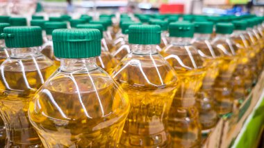 Bottles of oil on counter in shop, Pattern of vegetable oil bottles at factory warehouse store or supermarket