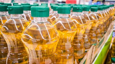 Bottles of oil on counter in shop, Pattern of vegetable oil bottles at factory warehouse store or supermarket