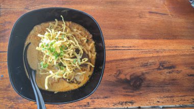 Khao Soi, Khao Soi Kai, Thai Noodles Khao Soi, ahşap zeminde baharatlı körili tavuk, Kuzey Tayland yemeği konsepti. (Lanna yemeği)