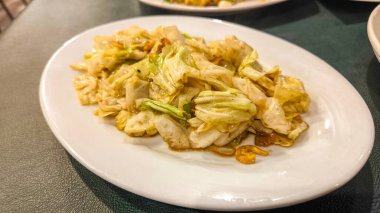 Balık soslu kızarmış lahana, beyaz tabakta Tayland yemeği.