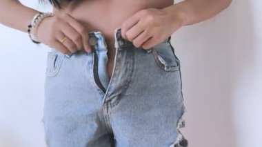 Kilolu bir kadın karnını sıkıyor ve aşırı kilolu olduğu için kendini kötü hissediyor..