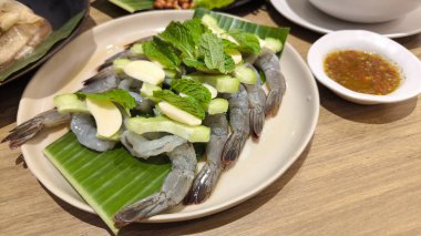 Balık soslu karides, acılı biber ve baharatlı Tayland yemeği. Yaprak süsleme stili.