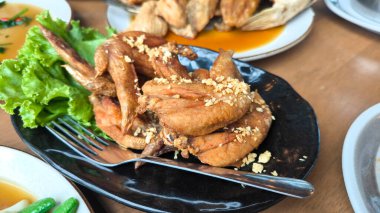 Kızarmış tavuk kanadı, çıtır tavuk kanadı, sarımsaklı tavuk kanadı, Tayland yemeği, Asya yemeği, kızarmış tavuk, sarımsaklı aroma, çıtır çıtır kızarmış yemek, Tayland mutfağı, tavuk aperatifi, Tayland yemeği, sokak yemeği, lezzetli yemekler, yemek fotoğrafçılığı, yemek tasarımı,