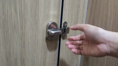 Kadın eli ahşap kapıyı açıyor ve girişi açıyor