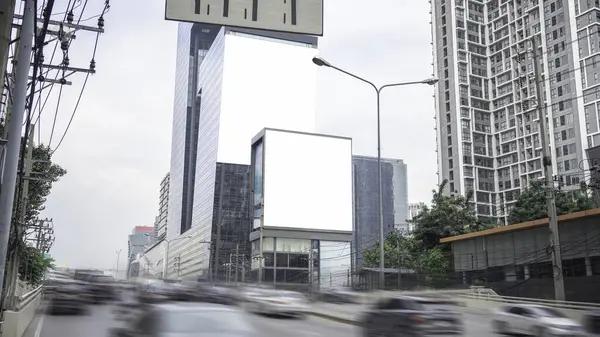 Advertising signs next to tall buildings in the city center Located along the driveway, clearly visible from a distance. It is an image suitable for use in writing, design work, or as a background