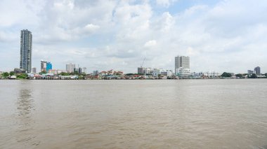 Banliyölerden akan büyük bir nehrin resmi. Huzurlu ve içinde yaşamak için hoş bir yer. Resimde sıra sıra dizilmiş küçük binaları görebilirsiniz. Sadece birkaç yüksek bina var..