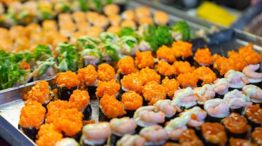 Deniz yosunlarına sarılı pirinç topları balık yumurtası, mürekkep balığı, karides yumurtası ve diğer popüler Japon yemekleri gibi çeşitli malzemelerle yüzünü süslüyor. Farklı aromalı soslarla kaplı..