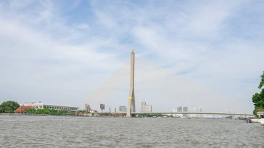 Rama VIII Köprüsü 'nün, Chao Phraya Nehri üzerindeki köprünün fotoğrafları. Bangkok 'un göbeğinde kıyı boyunca bir ekspres iskele ya da umumi su taksisi vardır. Arka plan mavi bir gökyüzü durini.