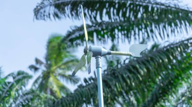 Daha önce kullanılmış çelikten yapılmış Pastel mavisi küçük yel değirmeninin fotoğrafları. Bir uçağa benzeyen uzun bir kuyruğu var. Türbin bıçakları rüzgara göre döner. 