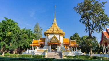 Beyaz tapınak altın Tayland desenleriyle süslenmiş. Wat Huai Mongkol Buda 'nın kutsal emanetlerini kutsadı. Çevresi uzun ağaçlarla çevrili. Karanlık doğa. 
