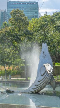 Konum fotoğrafları. Mavi yunus çeşmesi. Su fışkırıyor. Parklarda, plazalarda, açık alanlarda, yemyeşil alanlarda taze ve canlı görünüyor. Gündüz gölgeli atmosfer rahatlamaya elverişli