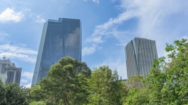 Yerlerin fotoğrafları, binaların manzaraları, başkentteki yüzlerce kat yüksekliğinde. Çoktan gelişti. Yanındaki mavi bina yapım aşamasında. Büyük ağaçlar aşağıda yeşil..