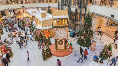 31 Aralık 2023 Malezya 'da Dessert Village' daki Replica saat kulesinin fotoğraflarında Noel teması parlak ışıklar ve gökkuşağı ile süslenmiştir. Mağazanın içinde bir sürü insan yürüyor.