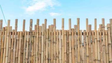 Konum fotoğrafları Japon tarzı açık kahverengi kuru bambu çitler geleneksel Japon kasabası tarzında uzun çitler. İçeriye bakınca, dükkanlarla dolu. Turistik eğlence sırasında gökyüzü açıktır.  