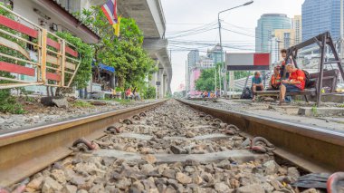 Kamu alanının bitişiğindeki demiryolu rayları yolun her iki tarafında da turistler var. Köylüler oturur ve dinlenir Demiryolu hattı gözünün alabildiğince uzar. 