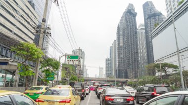 1 Ocak 2024 'te Bangkok, Tayland' da büyük bir şehrin ortasında 5 şeritli bir yolda kırmızı ışıkta park etmiş arabaların görüntüsü. Çok uzakta olmayan bir trafik işareti var..