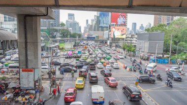 1 Ocak 2024 'te Bangkok, Tayland' da çeşitli araba ve motosiklet modellerinin trafiğinin görüntüleri. Bangkok 'un göbeğindeki kırmızı ışık kavşağında Gökyüzü yürüyüşünden