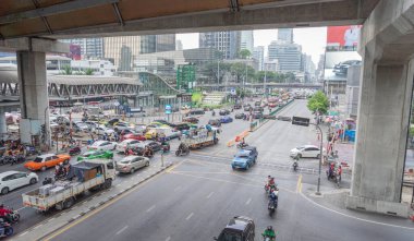 1 Ocak 2024 'te Bangkok, Tayland' da çeşitli araba ve motosiklet modellerinin trafiğinin görüntüleri. Bangkok 'un göbeğindeki kırmızı ışık kavşağında Gökyüzü yürüyüşünden