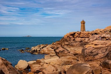 Ploumanac 'h Deniz Feneri' nin büyüleyici güzelliğini yakalayın. Fransa 'nın Brittany sahilinde yaz denizi manzaralı pembe granit bir yapı..