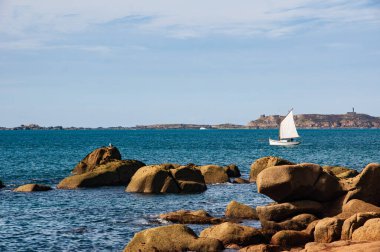 Ploumanach, Brittany, Fransa 'daki çarpıcı Pembe Granit Sahili boyunca kristal berrak sularıyla sakin bir yaz günü..