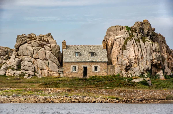 stock image A charming coastal cottage nestled among the rocky cliffs of Brittany, France, overlooking the mesmerizing sea.