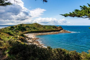 Cotes d 'Armor, Brittany, Fransa' daki Pointe de Bihit 'te açık mavi gökyüzü ve sakin denizle baş döndürücü bir yaz sahnesi..