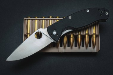 Taktiksel katlama bıçağı ve tüfek fişekleri. Yüksek kalite fotoğraf