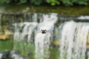 Bir yaz günü şelalede uçan küçük bir dron. Yüksek kalite fotoğraf