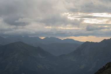 Polonyalı Tatralar 'da güneş batarken bulutların arasından büyüleyici dağ manzarası. Yüksek kalite fotoğraf